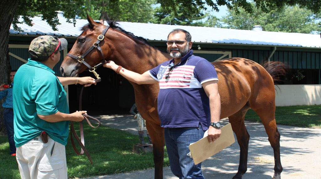 Harisharan Devgan is standing with horse and horse trainer